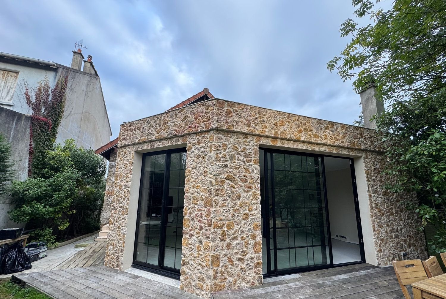 Extension en pierre meulière et baies vitrées réalisée par MJF Bâtiment
